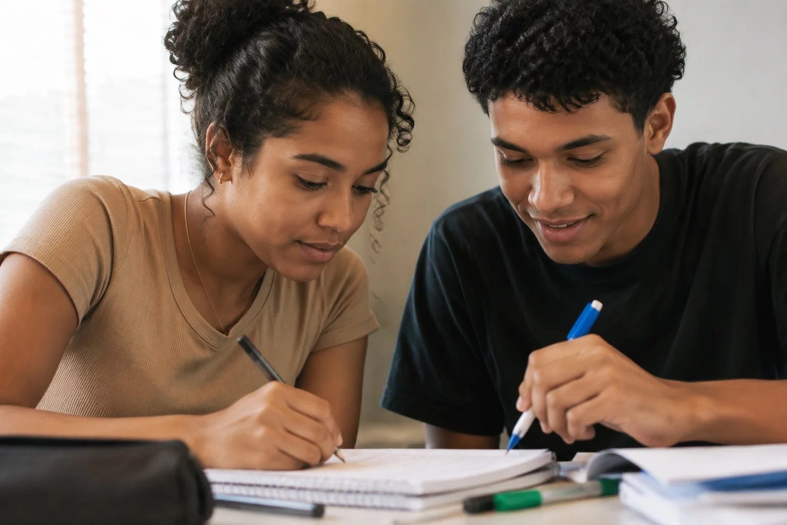 Dois estudantes preparando um debate com cadernos e marcadores